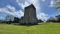 a castle in ireland with a grassy field in the background